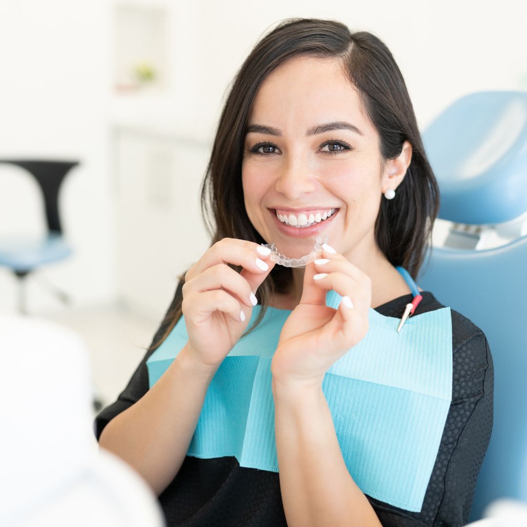 woman at the orthodontist holding her Invisalign