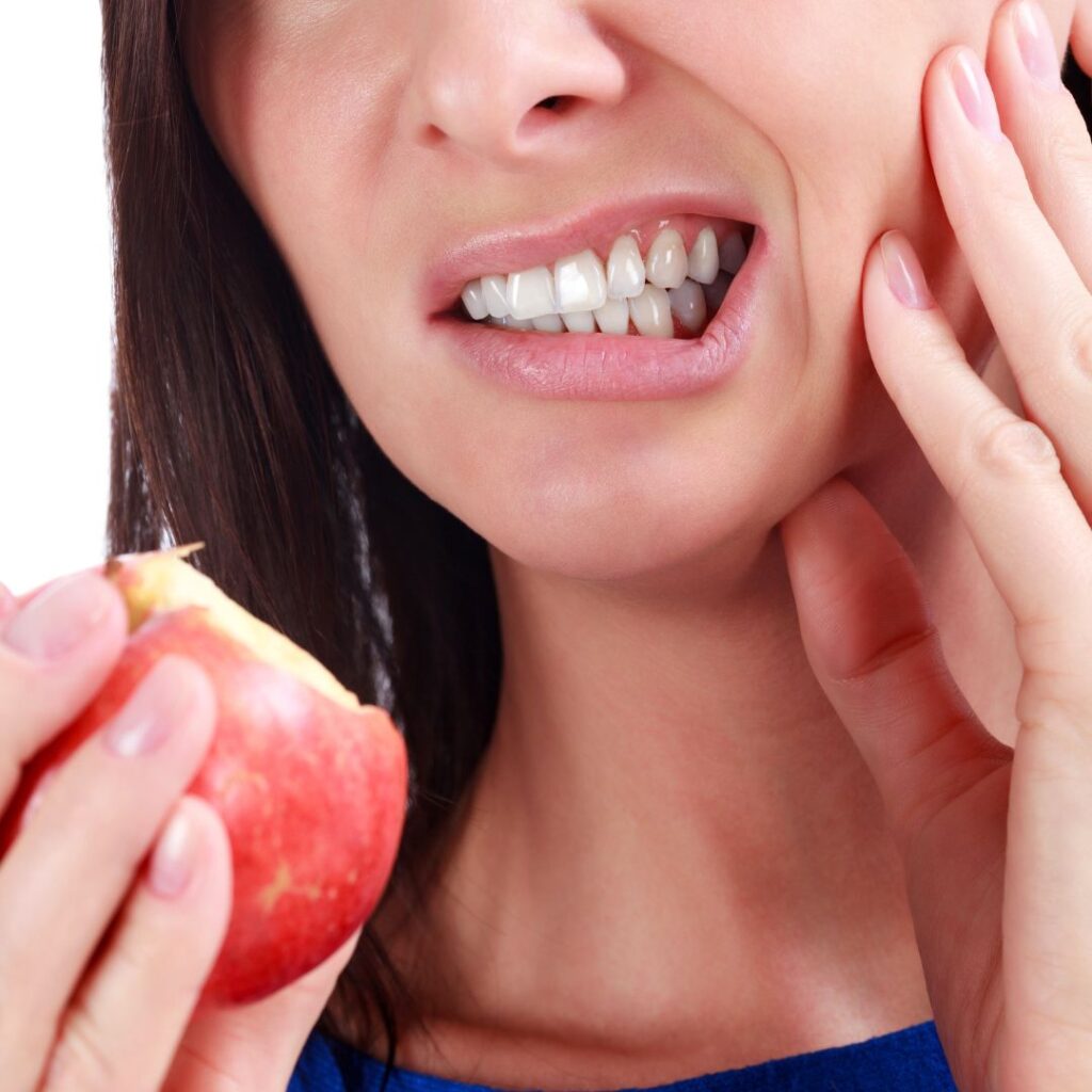 Person eating apple with some tooth pain